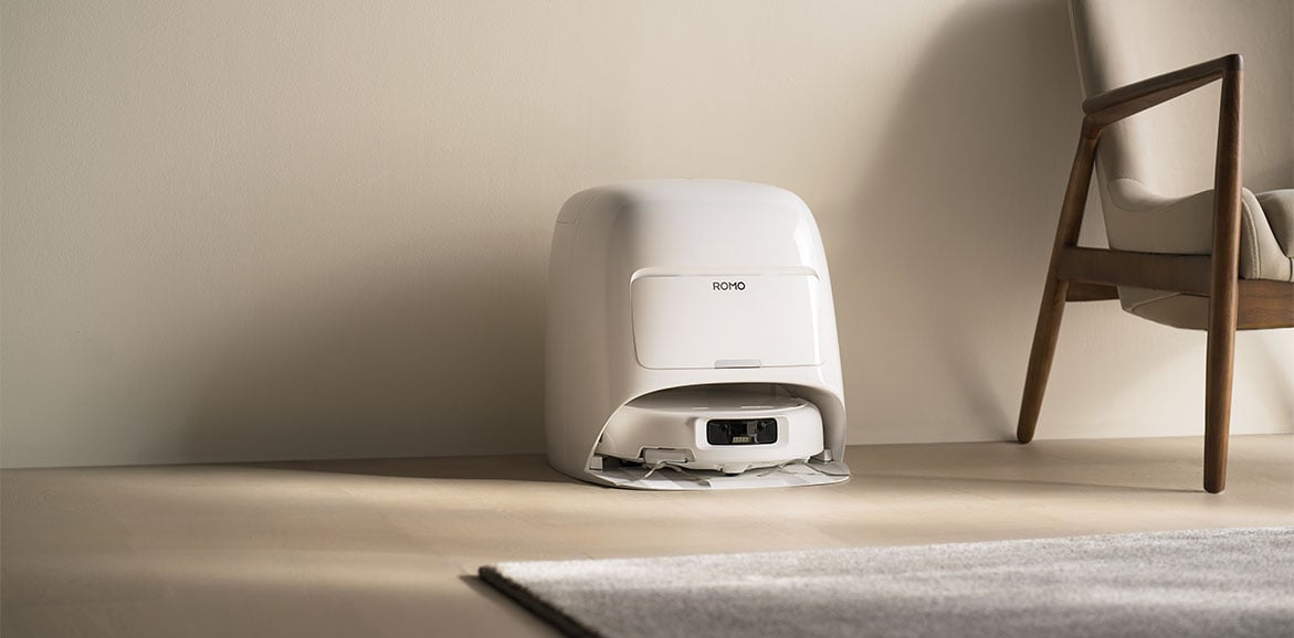 Robot sprzątający DJI ROMO S w stacji dokującej w beżowym pokoju